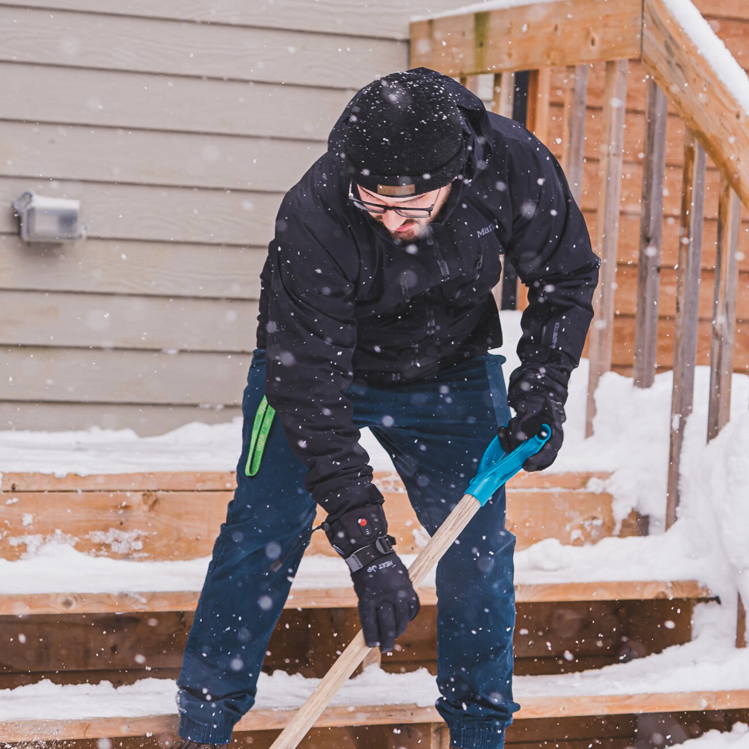 Person shoveling snow from a set of stairs on a snowy day