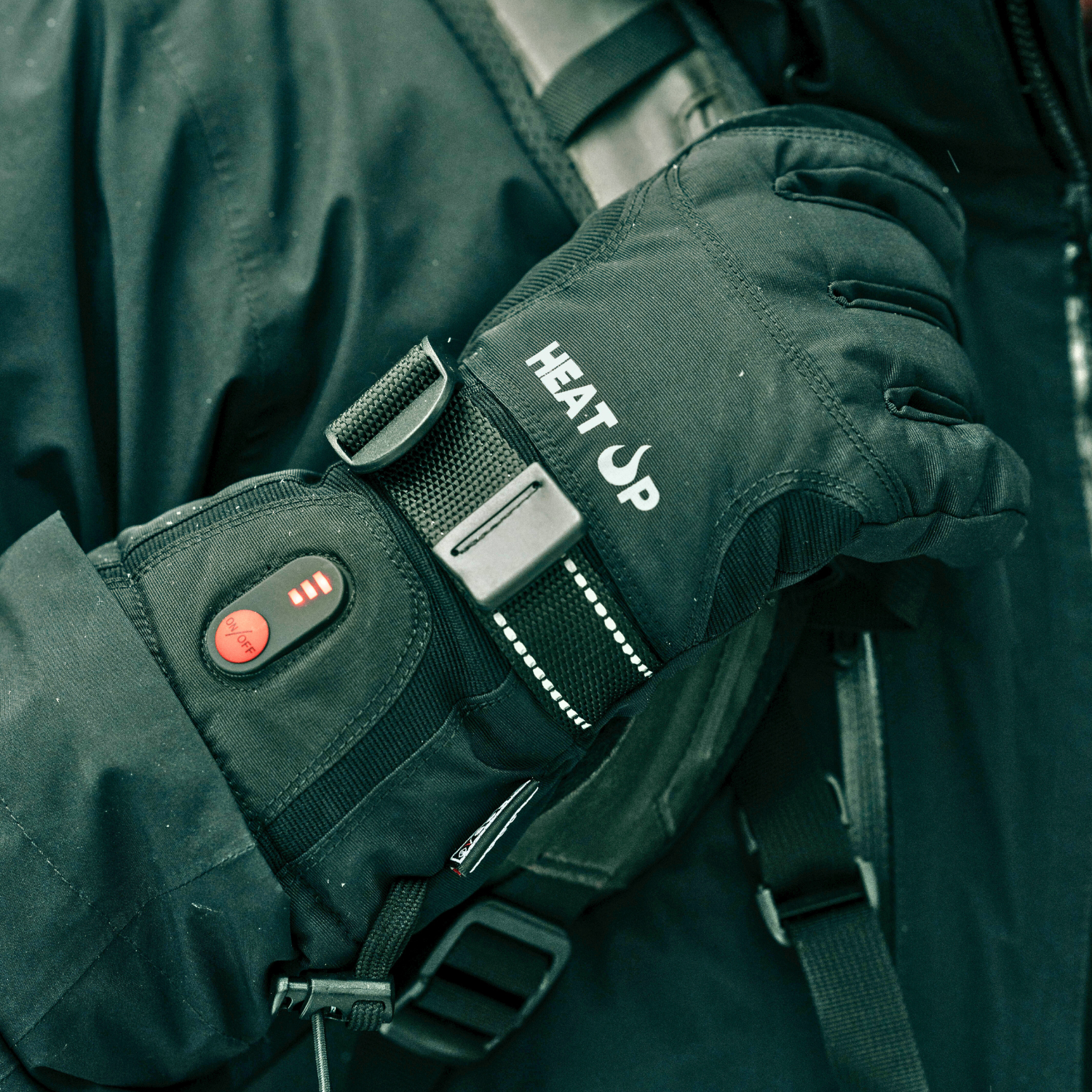 Black heated glove with 'Heat Up' branding on a dark background