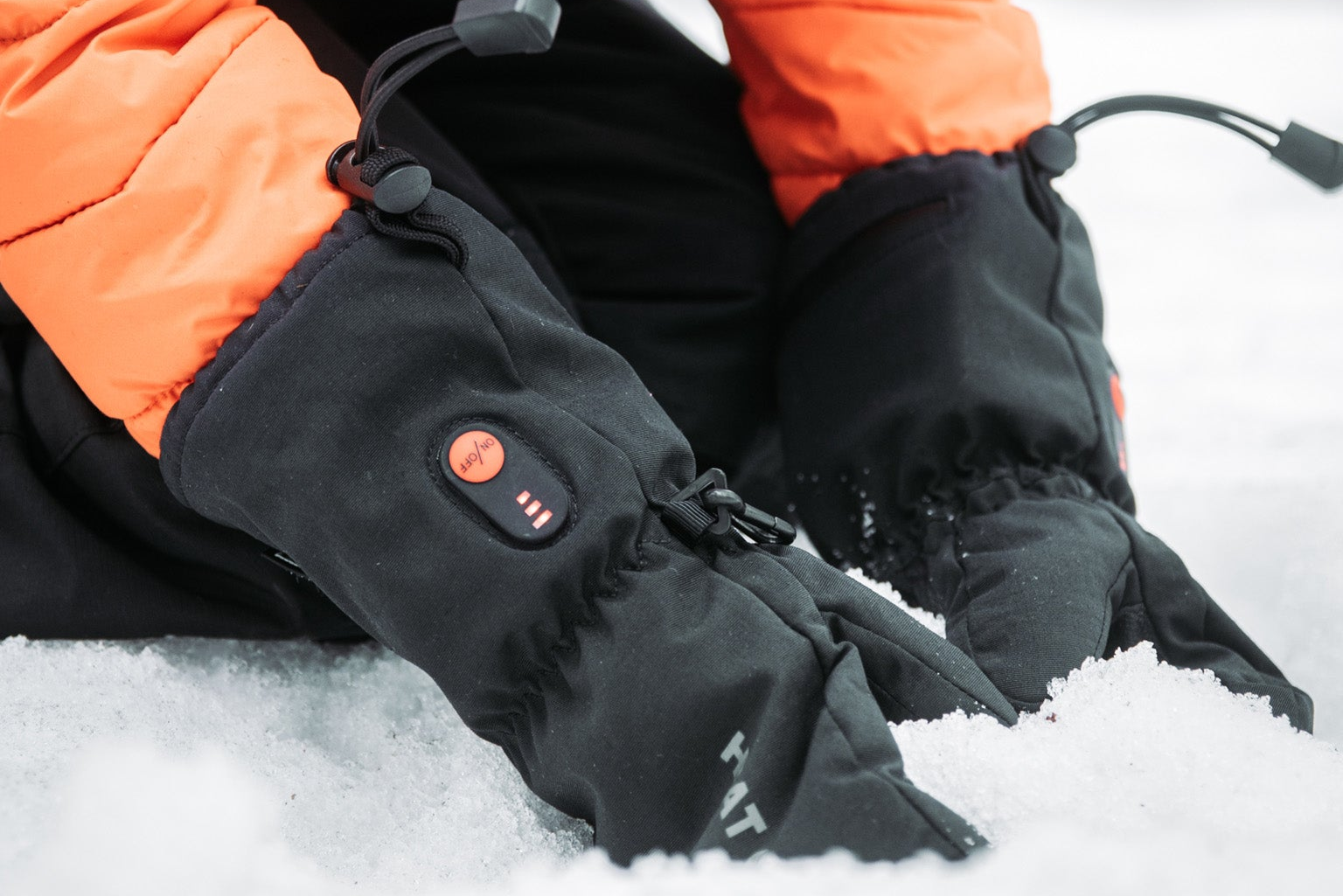 Person wearing heated gloves in a snowy setting