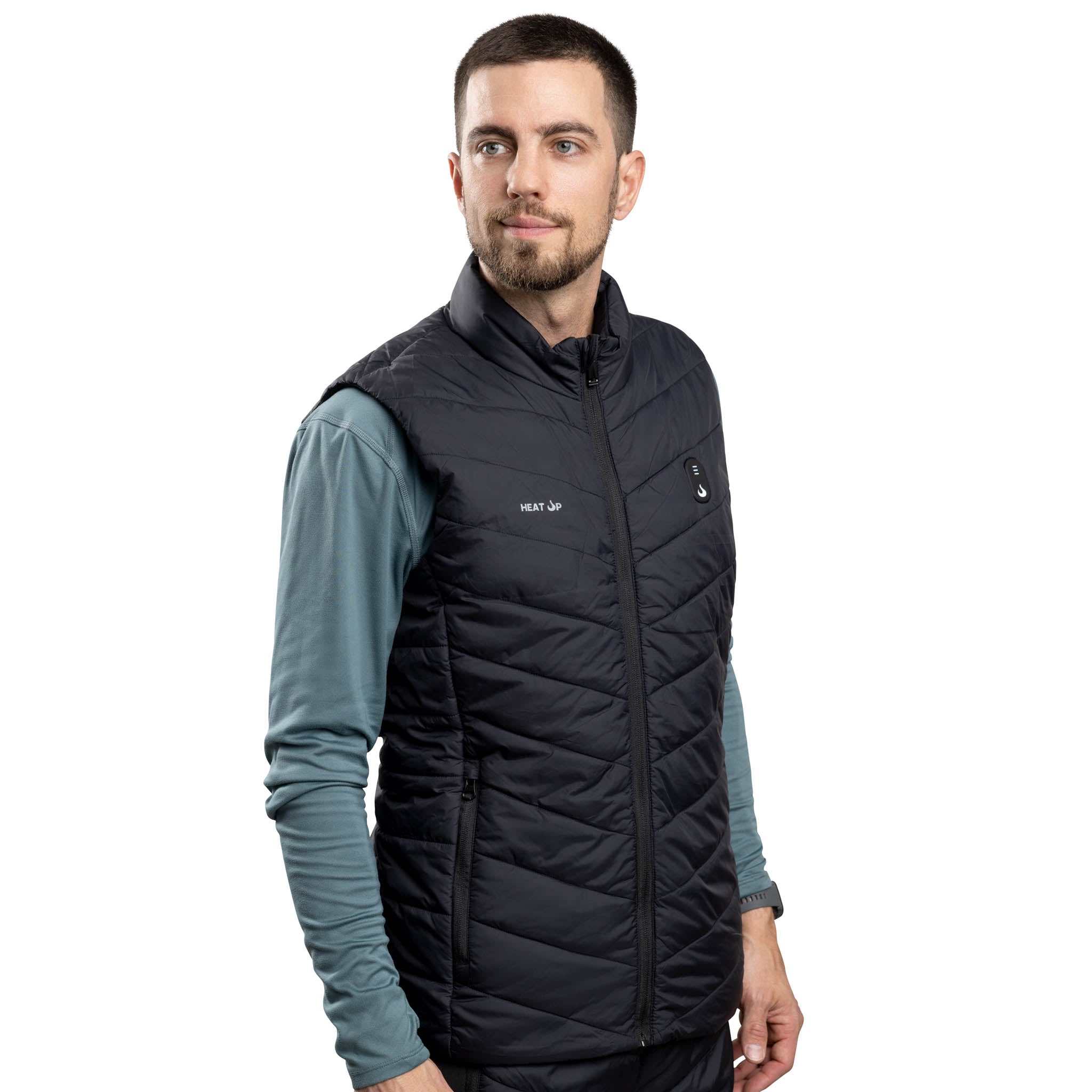 Man wearing a black quilted vest over a long-sleeve shirt on a white background