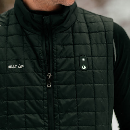 Person wearing a black quilted jacket with visible branding in a blurred outdoor setting