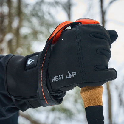 Black glove with orange accents holding a tool, with 'HEAT UP' branding, against a blurred natural background.