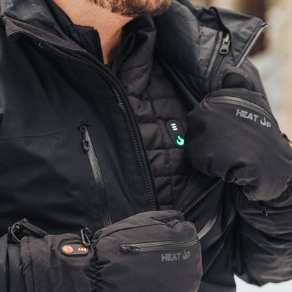 Person wearing a black heated jacket and gloves with 'Heat Up' branding.