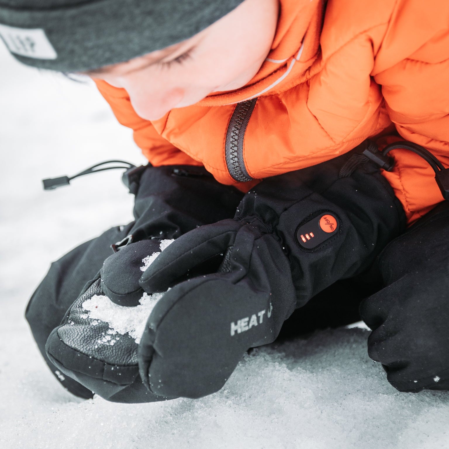 Person wearing heated gloves in a snowy environment