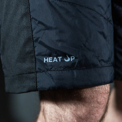Close-up of a person wearing black shorts with 'HEAT UP' branding.