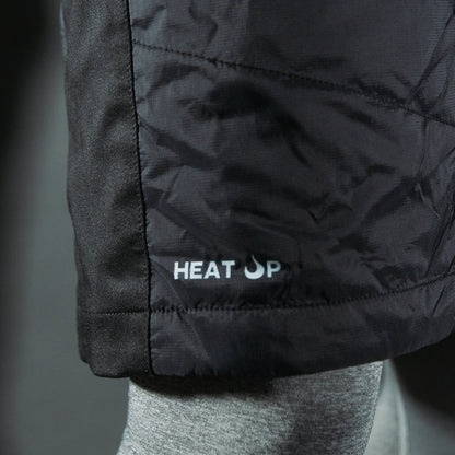 Close-up of a black jacket with 'HEAT UP' logo on a blurred background