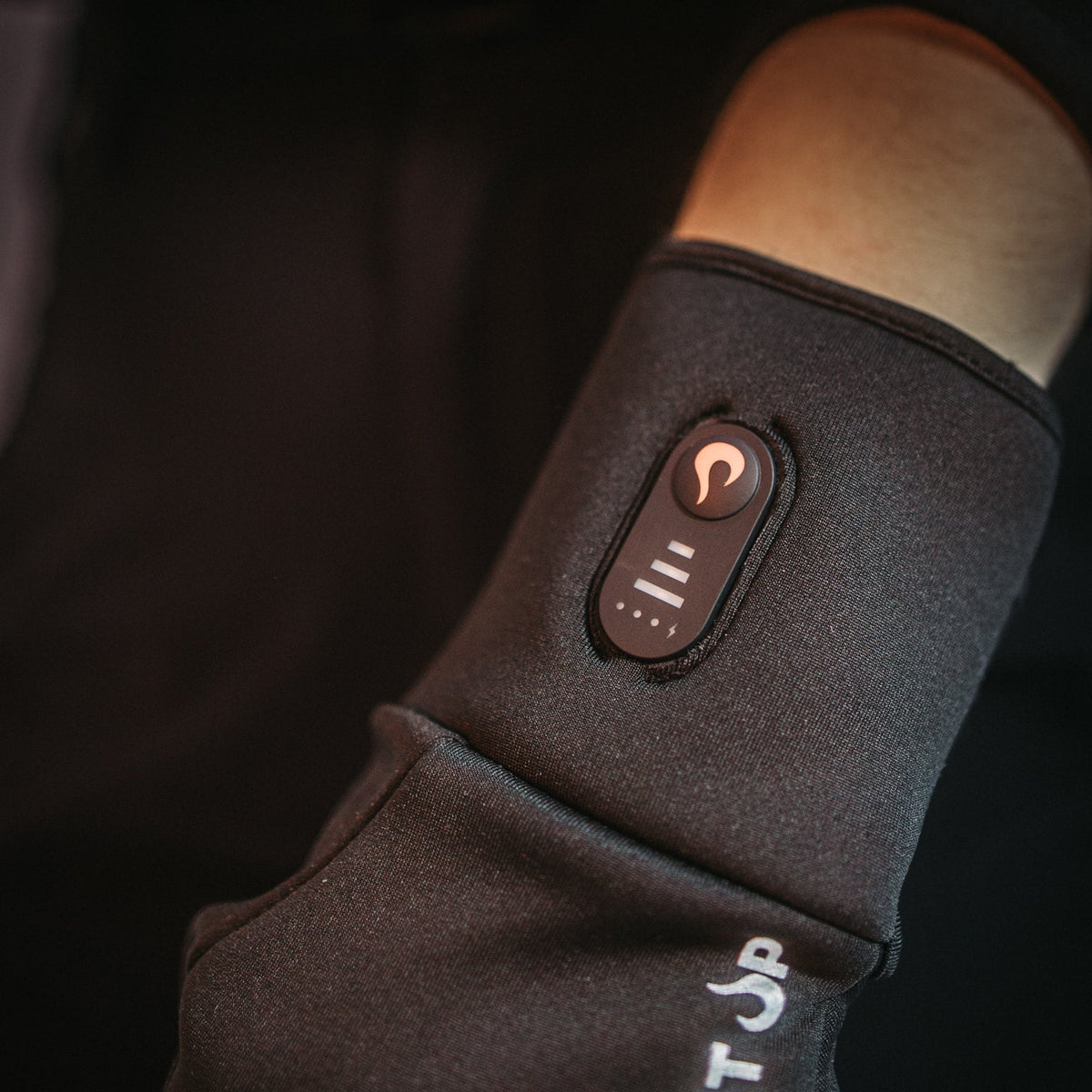 Close-up of the heat button and level indicator on the wrist of a Heat Up Active heated glove