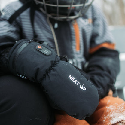 Enfant avec un casque de hockey portant des mitaines chauffantes Junior Heat Up, bouton de chaleur allumé